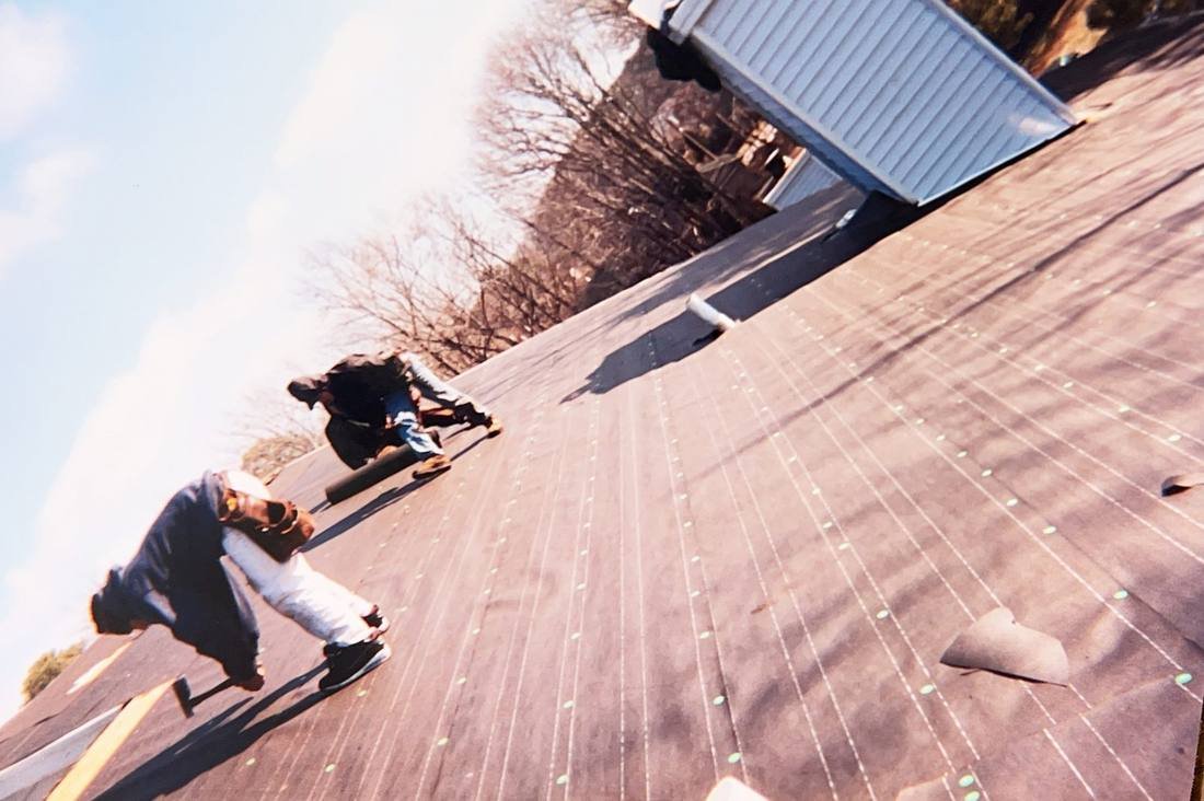 GEJ Roofing crew installing shingles during the early years on the road