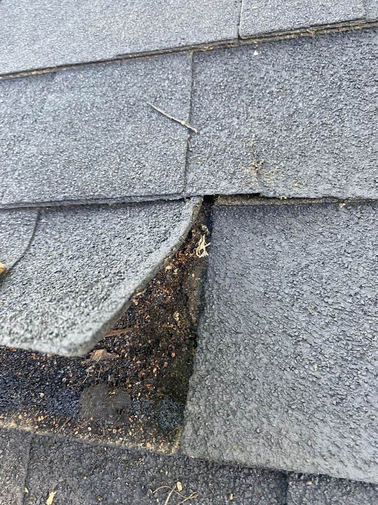 Close-up of a shingle gap and exposed underlayment found during a roof leak inspection in Nashville, Tennessee
