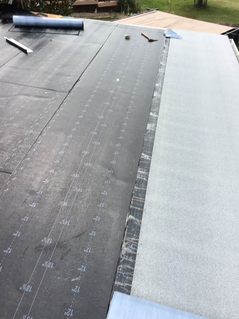 Flat roof membrane being installed over insulation board, Tennessee