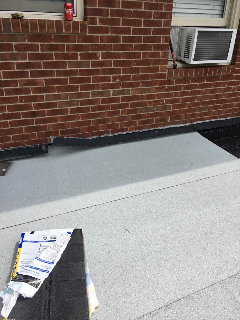 Close-up of flat roof membrane sealed against a brick parapet wall, Tennessee
