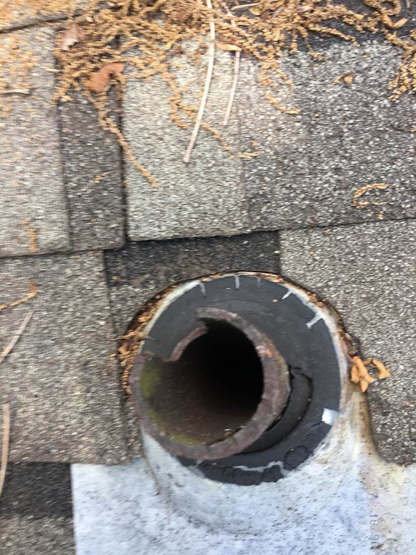 Close-up of a rusted and deteriorated plumbing vent pipe before replacement, Tennessee