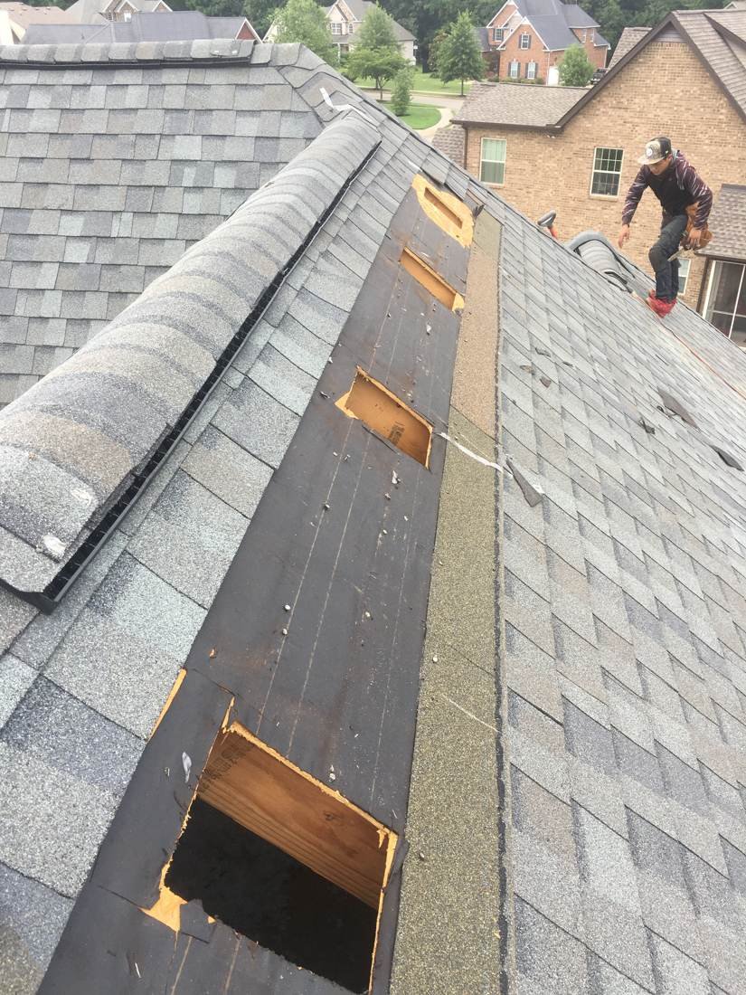 Overview of a roof with several cut-out and repaired decking sections, Tennessee