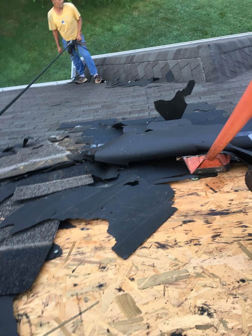 Old felt underlayment being removed during a roof tear-off, Tennessee