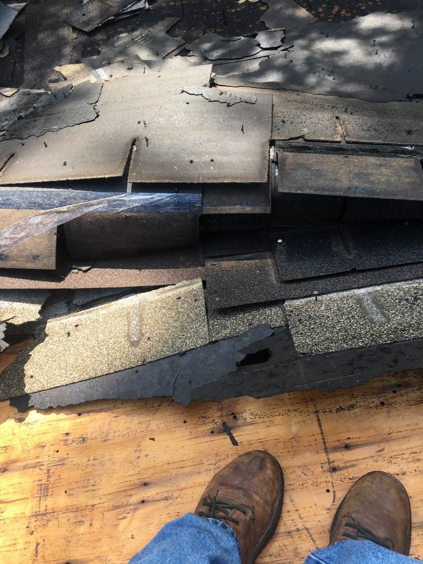 Old, deteriorated shingles torn off a roof during a roof replacement, Tennessee