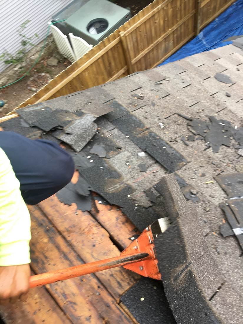 Crew tearing off an old shingle roof on a brick house, Tennessee