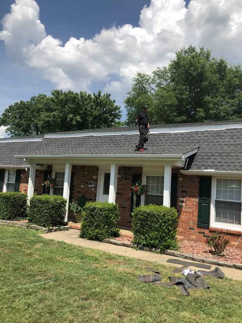 Roofer walking the ridge of a newly completed hip roof on a home in Middle Tennessee