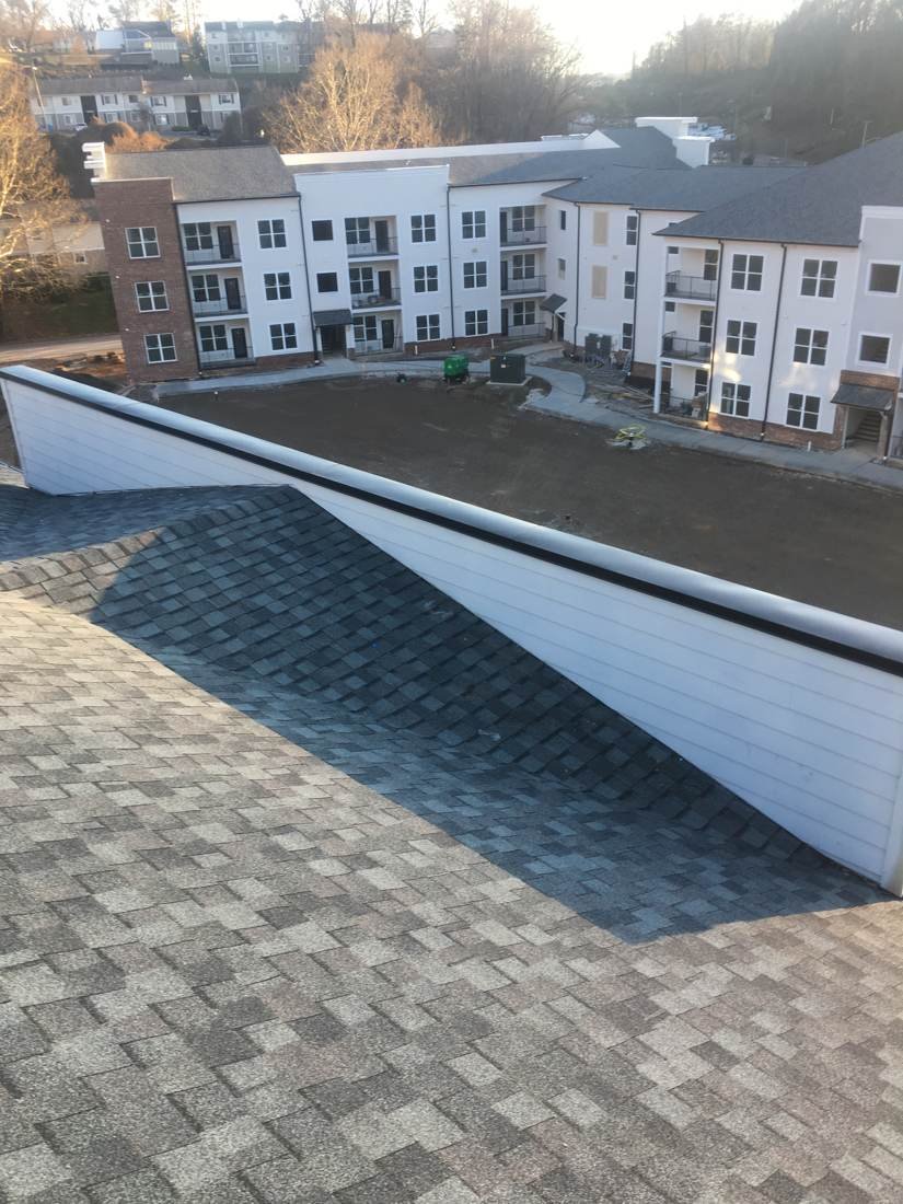 Completed shingle roof on an apartment building in Knoxville, Tennessee, viewed from an adjacent rooftop