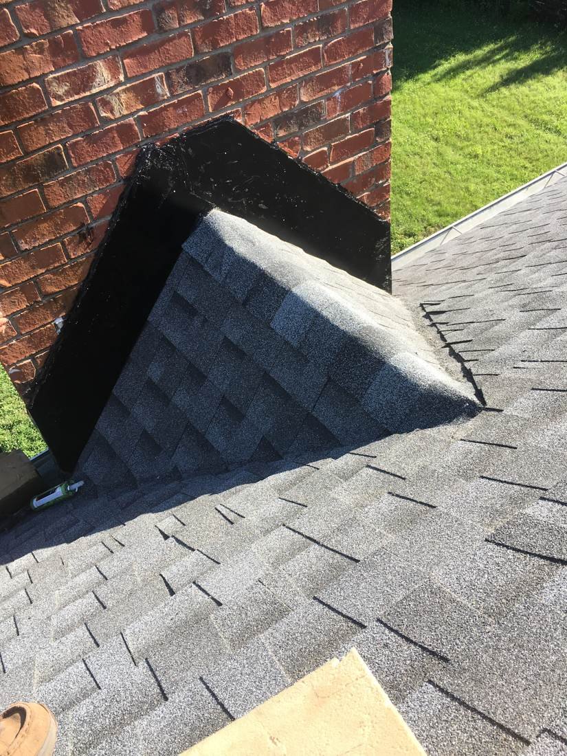 Finished roof cricket built behind a wide brick chimney to divert water, Murfreesboro TN