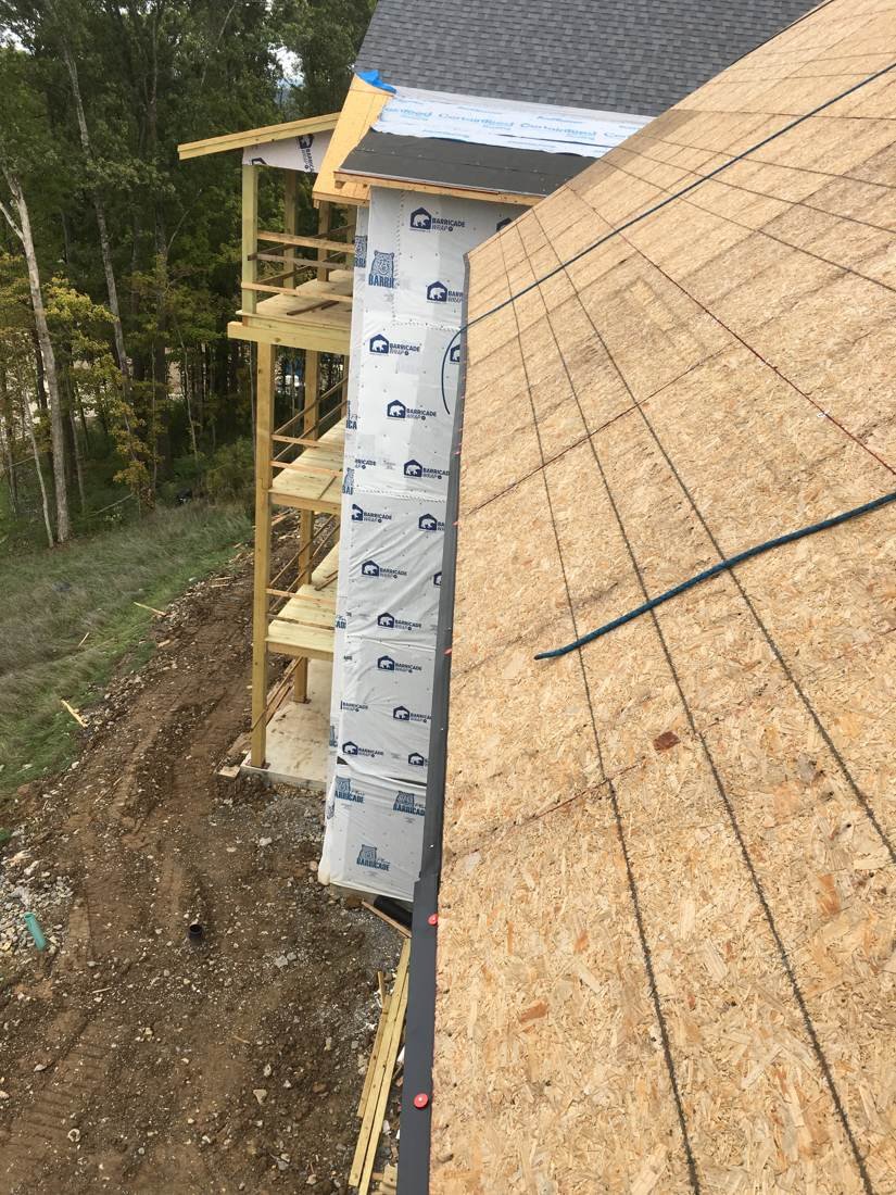 Roof decking with shingle course chalk lines snapped and drip edge installed on a new-construction apartment building near downtown Nashville, Tennessee