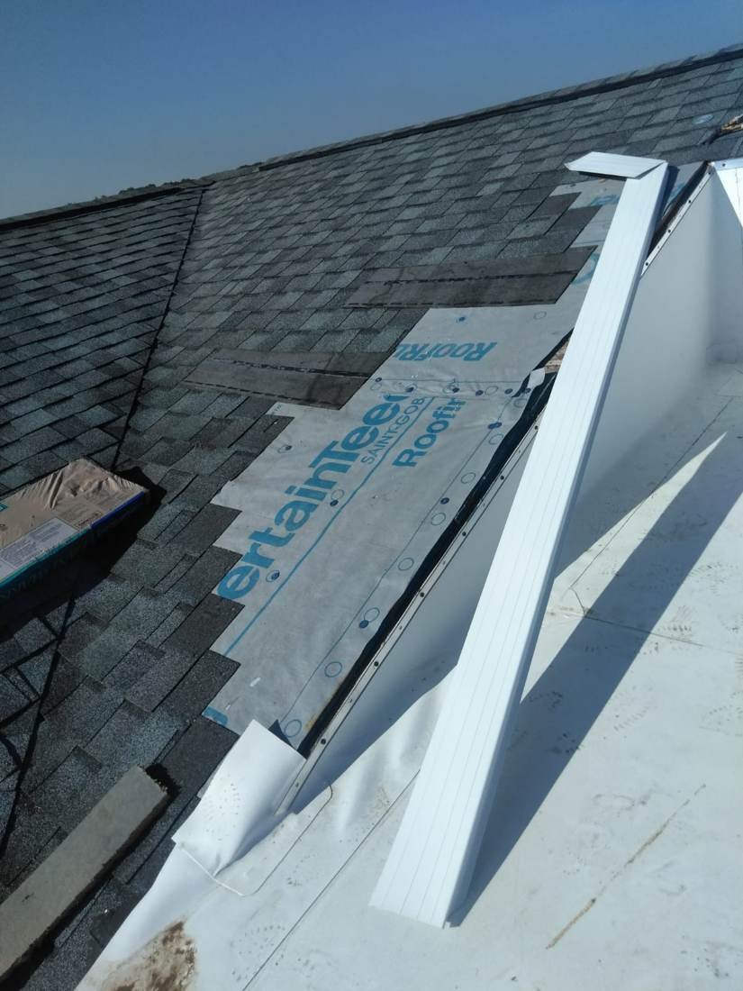 Flat roof membrane tying into a shingled slope roof with new wall flashing, new-construction apartment building near downtown Nashville, Tennessee