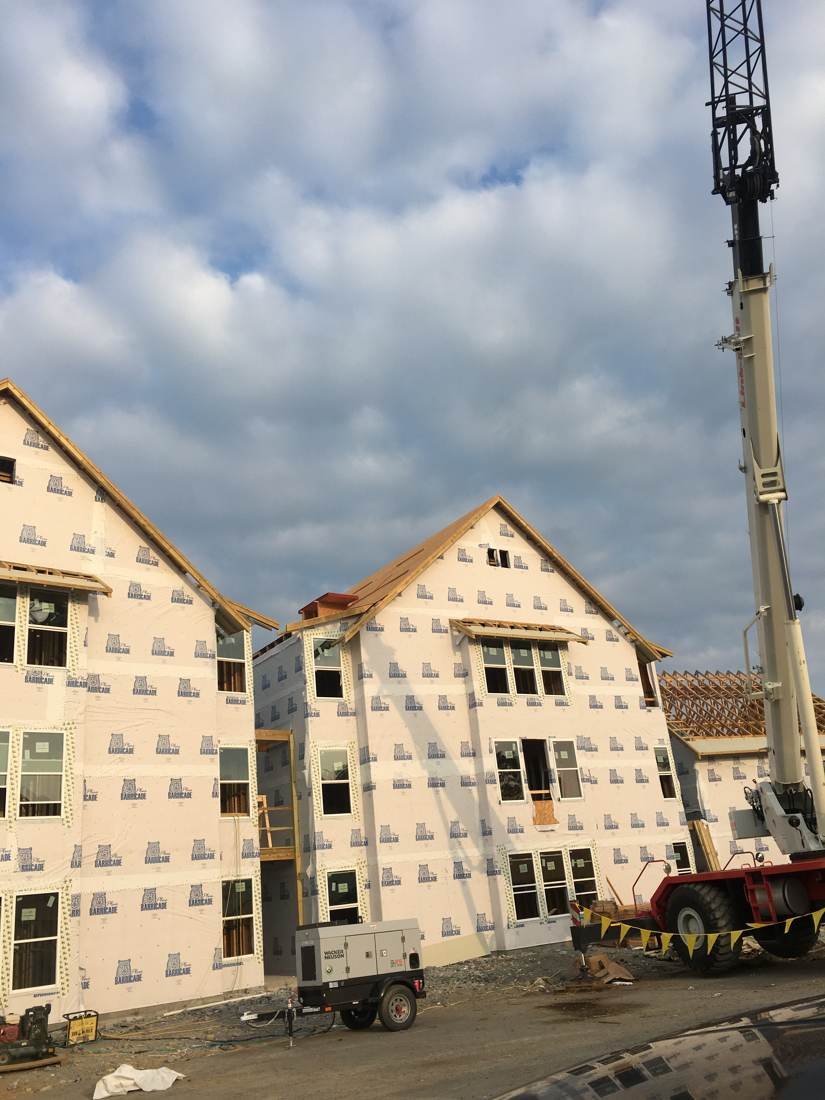 New-construction apartment building under roof and wall framing near downtown Nashville, Tennessee, with a crane on site