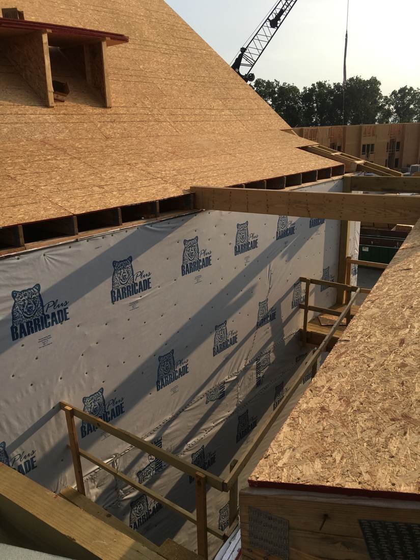 Crew installing OSB roof decking on a new-construction apartment building near downtown Nashville, Tennessee