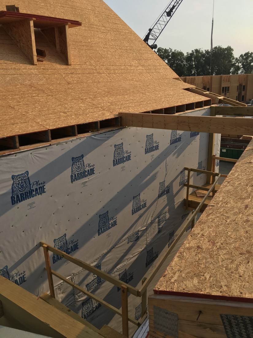 Roof decking installation in progress on a new apartment building near downtown Nashville, Tennessee, with a crane visible