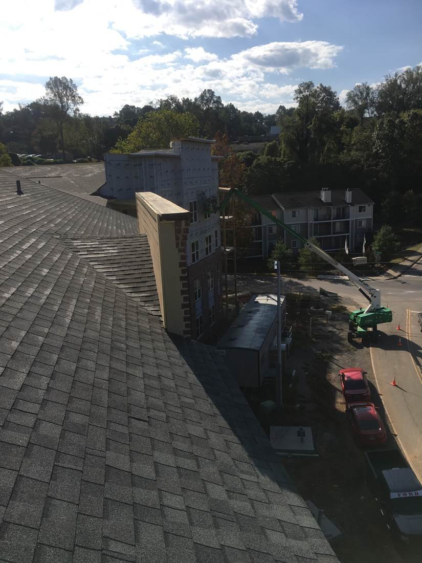 Wide overview from a finished roof showing a later construction phase of the apartment complex near downtown Nashville, Tennessee, with a boom lift on the street