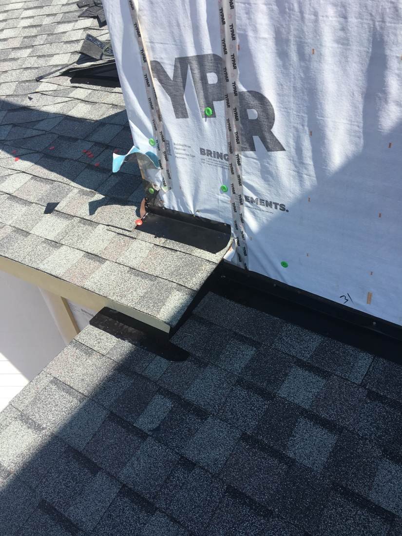 House wrap meeting new drip edge and shingles at a wall tie-in, new-construction apartment building near downtown Nashville, Tennessee