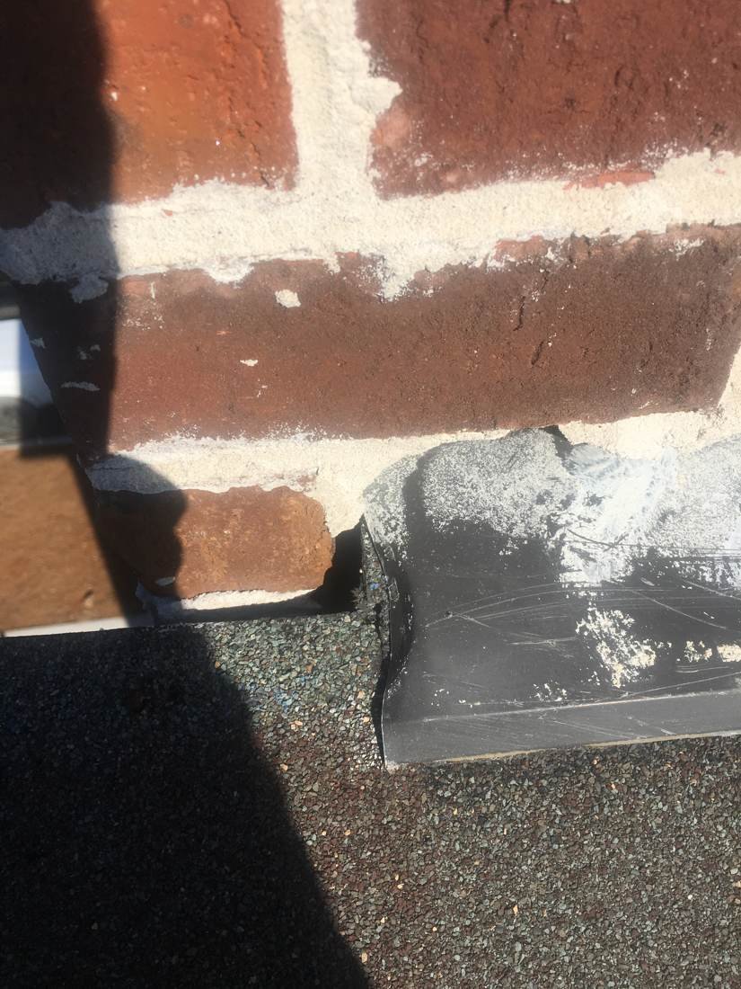 Checking chimney flashing for gaps during a GEJ Roofing inspection