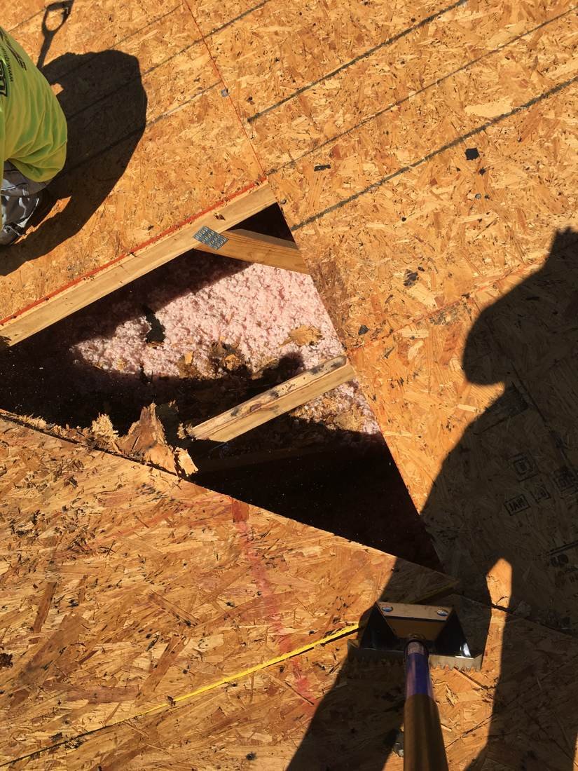 Measuring a section of rotted decking for repair during an apartment complex reroof, Statesboro, Georgia